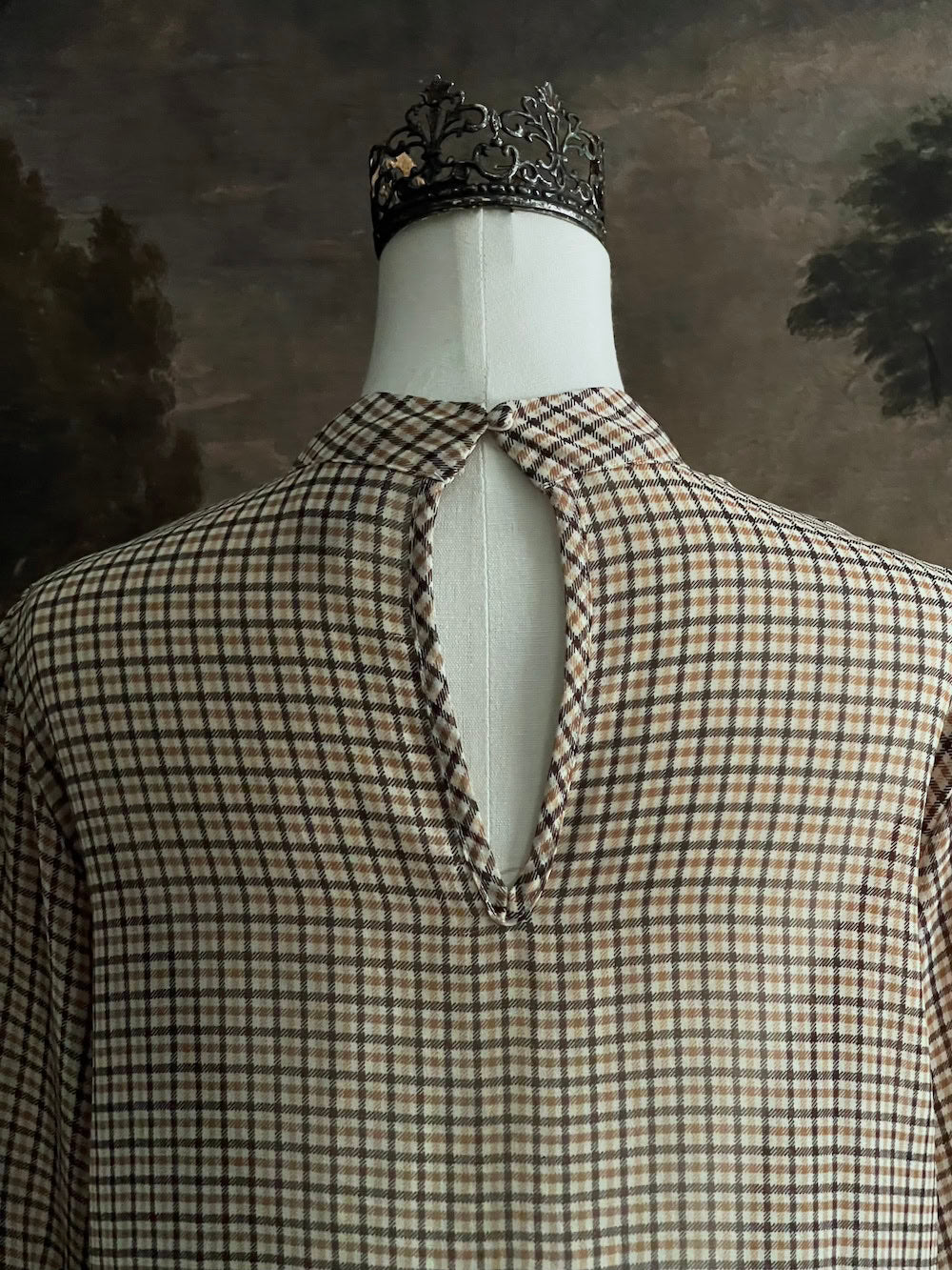 Mannequin wearing a vintage style historically inspired gingham check plaid blouse with bell sleeves and a mock neckline