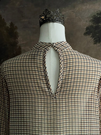 Mannequin wearing a vintage style historically inspired gingham check plaid blouse with bell sleeves and a mock neckline