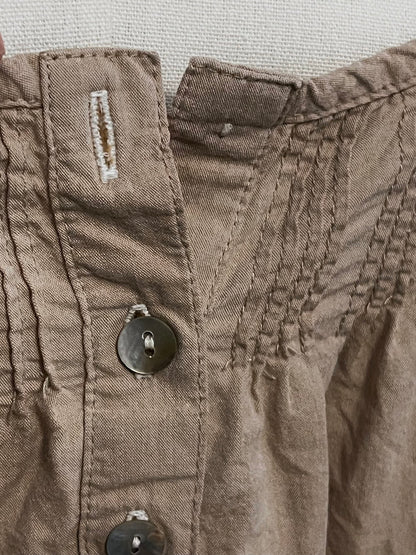 Close-up of a brown fabric with stitching details and a button.