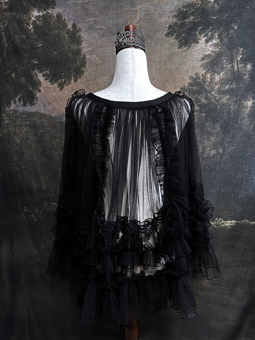 A versatile historically inspired overskirt and cape with lace trim and ruffle details in gothic black