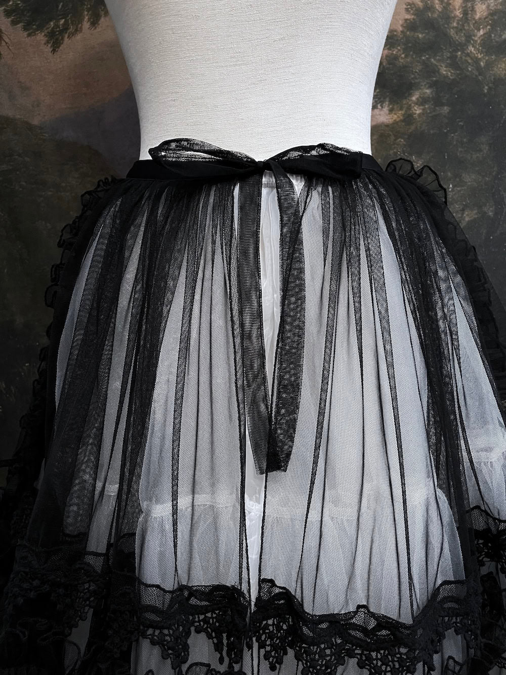 A versatile historically inspired overskirt and cape with lace trim and ruffle details in gothic black