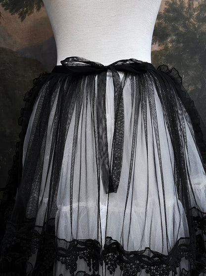 A versatile historically inspired overskirt and cape with lace trim and ruffle details in gothic black