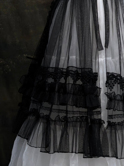 A versatile historically inspired overskirt and cape with lace trim and ruffle details in gothic black