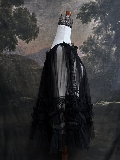 A versatile historically inspired overskirt and cape with lace trim and ruffle details in gothic black