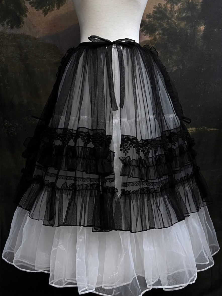 A versatile historically inspired overskirt and cape with lace trim and ruffle details in gothic black