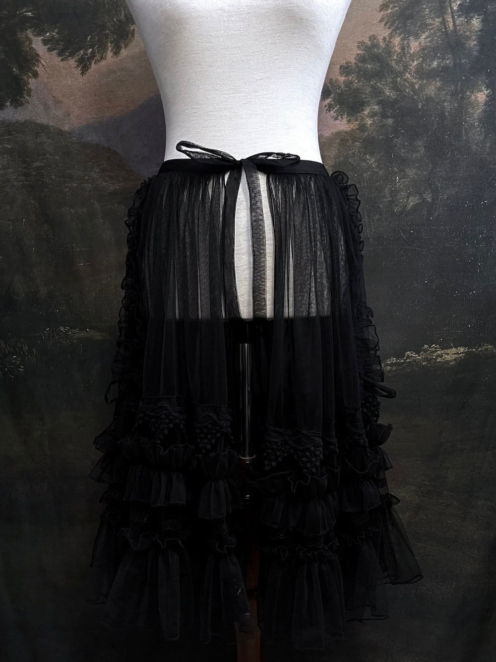 A versatile historically inspired overskirt and cape with lace trim and ruffle details in gothic black