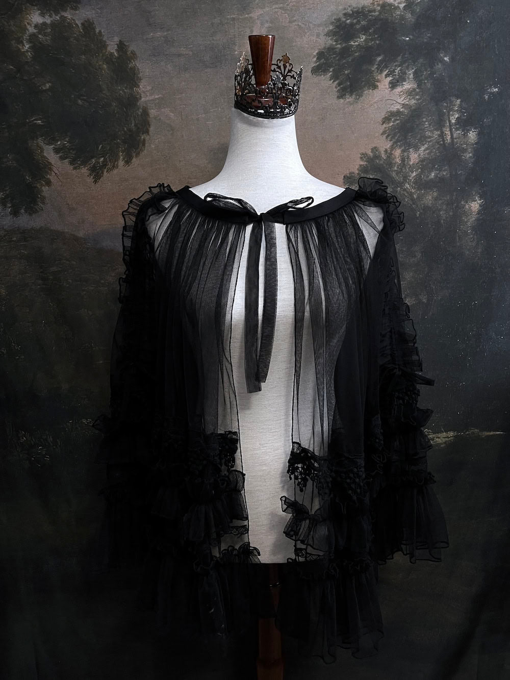 A versatile historically inspired overskirt and cape with lace trim and ruffle details in gothic black