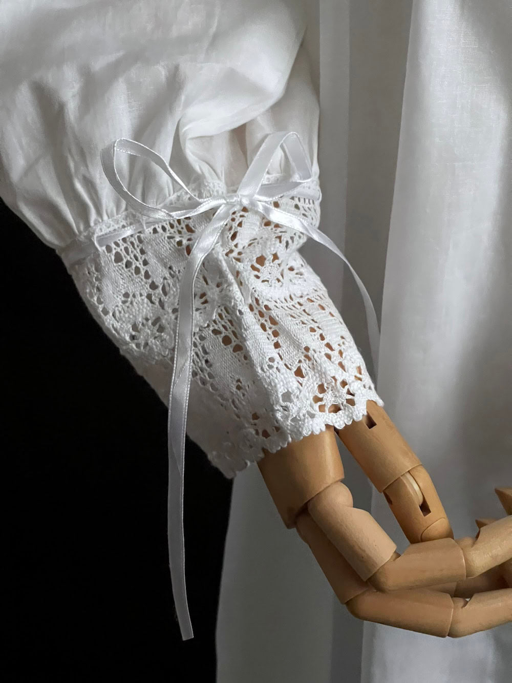 Detail of crochet lace cuff with ribbon bow