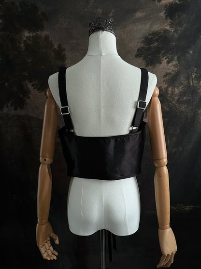 Black fantasy inspired underbust satin corset belt on a mannequin in front og an art history backdrop