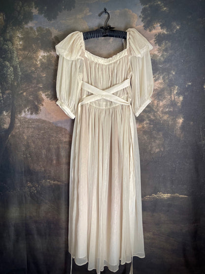 A Historically Inspired Renaissance to Victorian era Pleated Gauzy Chiffon Gown in Ivory, pictured on a mannequin in front of an art history backdrop.