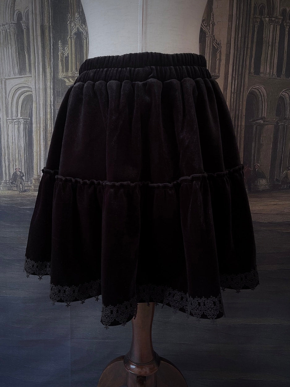 A Historically Inspired Renaissance and Medieval Style Gothic Lace-Trimmed Velvet Mini Skirt in Black with Bow appliques.