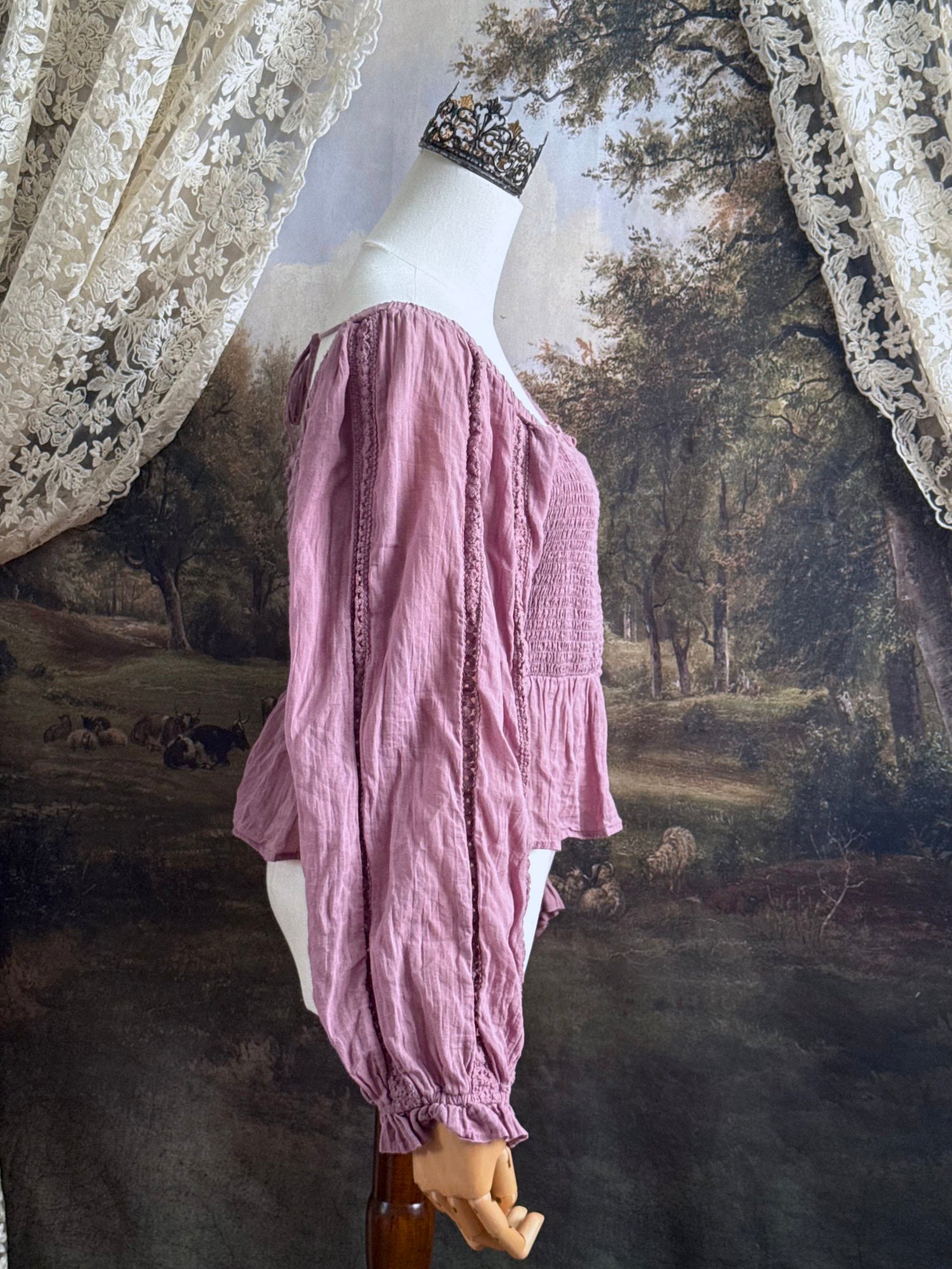 A historically inspired mauve pink shirred cotton peasant blouse with long bishop sleeves pictured on a mannequin