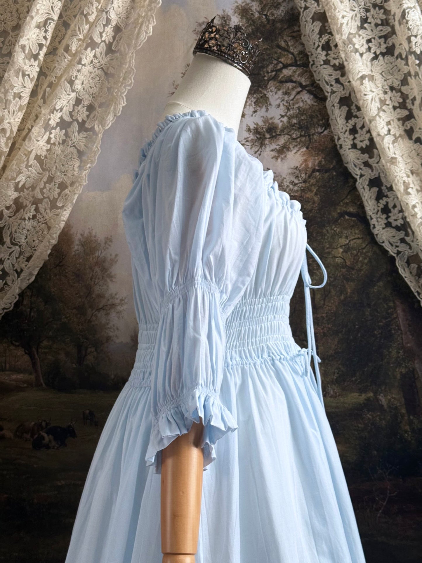 A historically-inspired vintage style light blue shirred / smocked cotton maxi chemise dress with half length virago puff sleeves, pictured on a mannequin