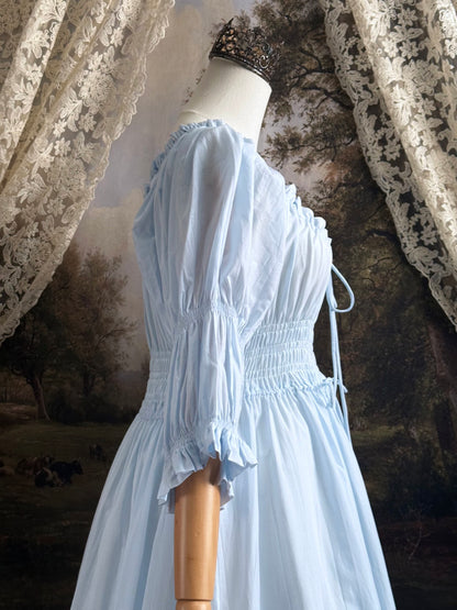 A historically-inspired vintage style light blue shirred / smocked cotton maxi chemise dress with half length virago puff sleeves, pictured on a mannequin