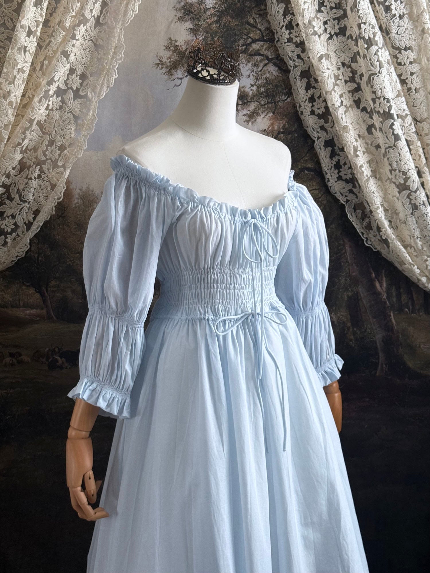 A historically-inspired vintage style light blue shirred / smocked cotton maxi chemise dress with half length virago puff sleeves, pictured on a mannequin
