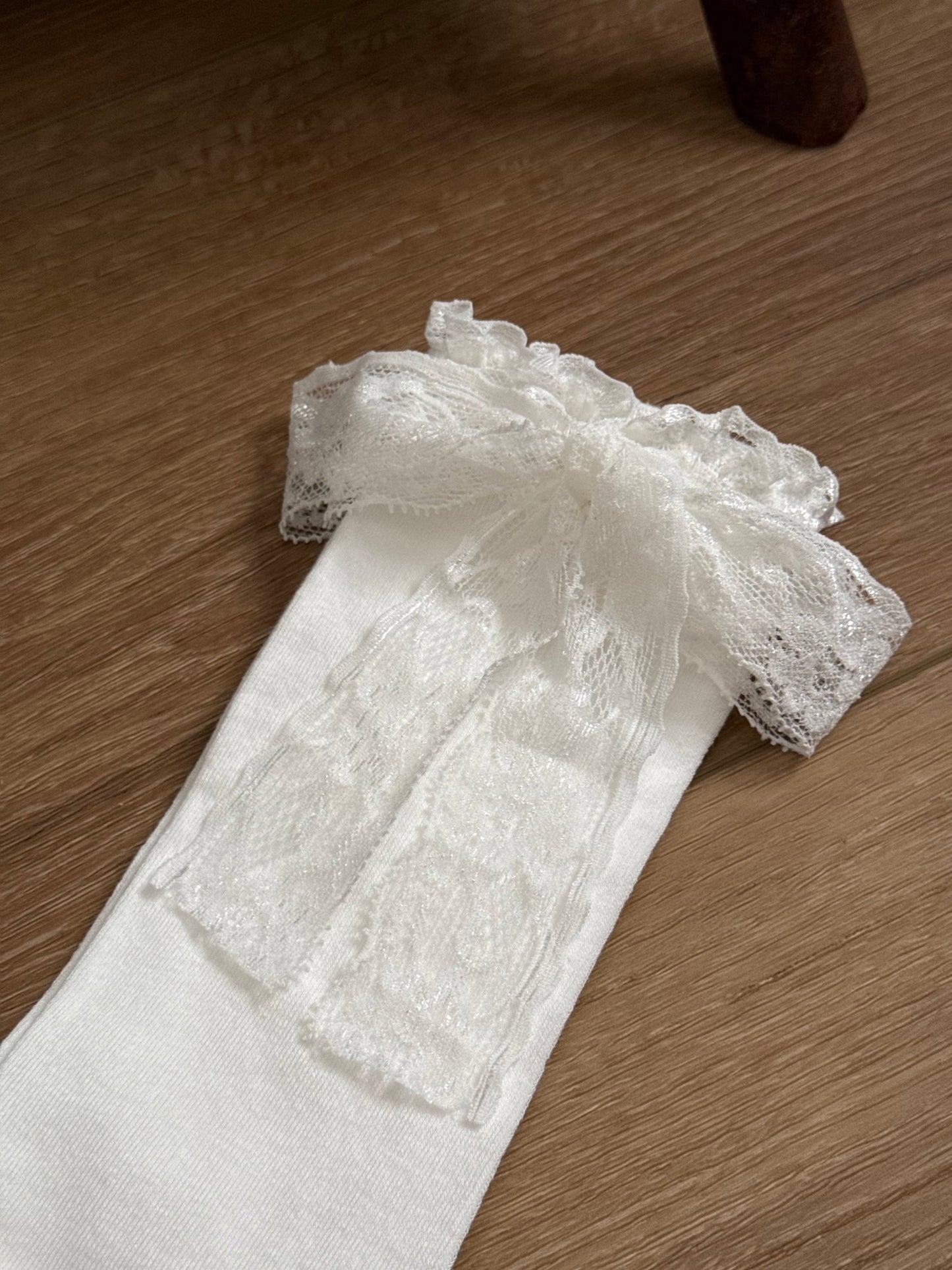 Historically inspired off-white cotton stockings with lace trim and bow ribbons for medieval, renaissance, tudor, baroque, rococo, regency, victorian, and edwardian outfits.