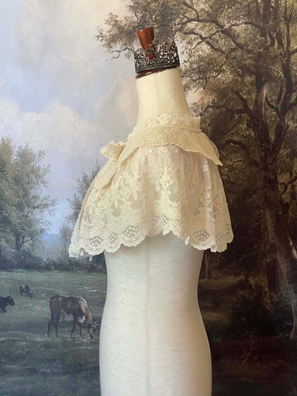 A Historically inspired edwardian victorian regency and rococo style lace capelet shawl in ivory with bow and floral embroidered details.