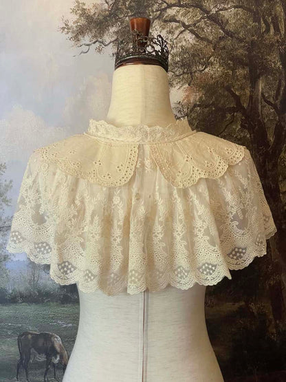 A Historically inspired edwardian victorian regency and rococo style lace capelet shawl in ivory with bow and floral embroidered details.