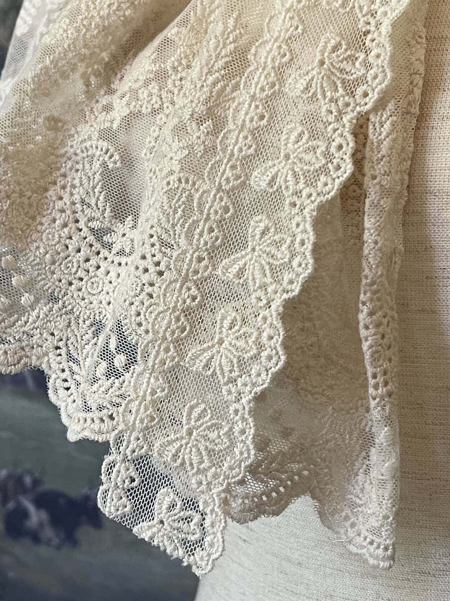 A Historically inspired edwardian victorian regency and rococo style lace capelet shawl in ivory with bow and floral embroidered details.