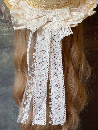 A Historically Inspired straw boater hat on a mannequin. Decorated with cotton crochet floral lace bows.