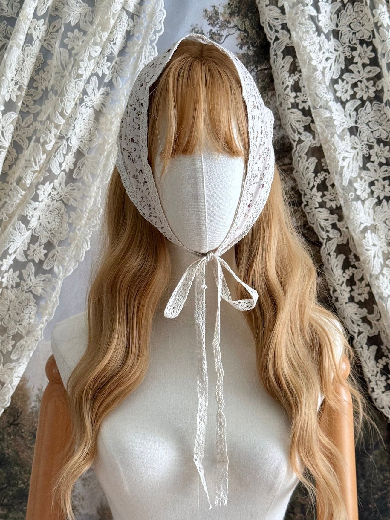 A Vintage inspired Cream & Pink Floral Print Babushka Triangle Headdress with lace trim on a mannequin head