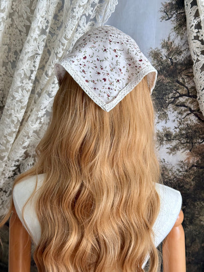 A Vintage inspired Cream & Pink Floral Print Babushka Triangle Headdress with lace trim on a mannequin head