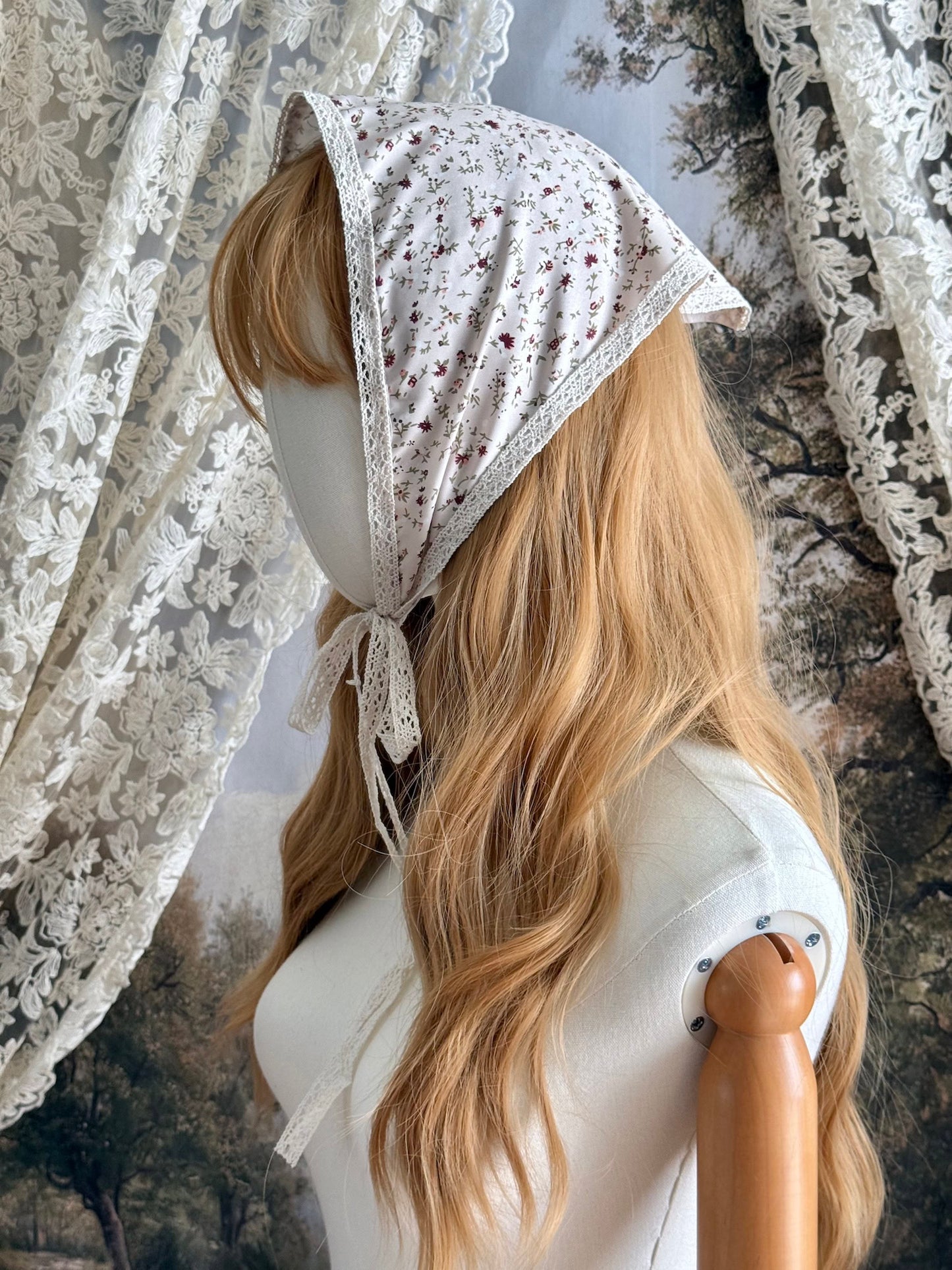 A Vintage inspired Cream & Pink Floral Print Babushka Triangle Headdress with lace trim on a mannequin head