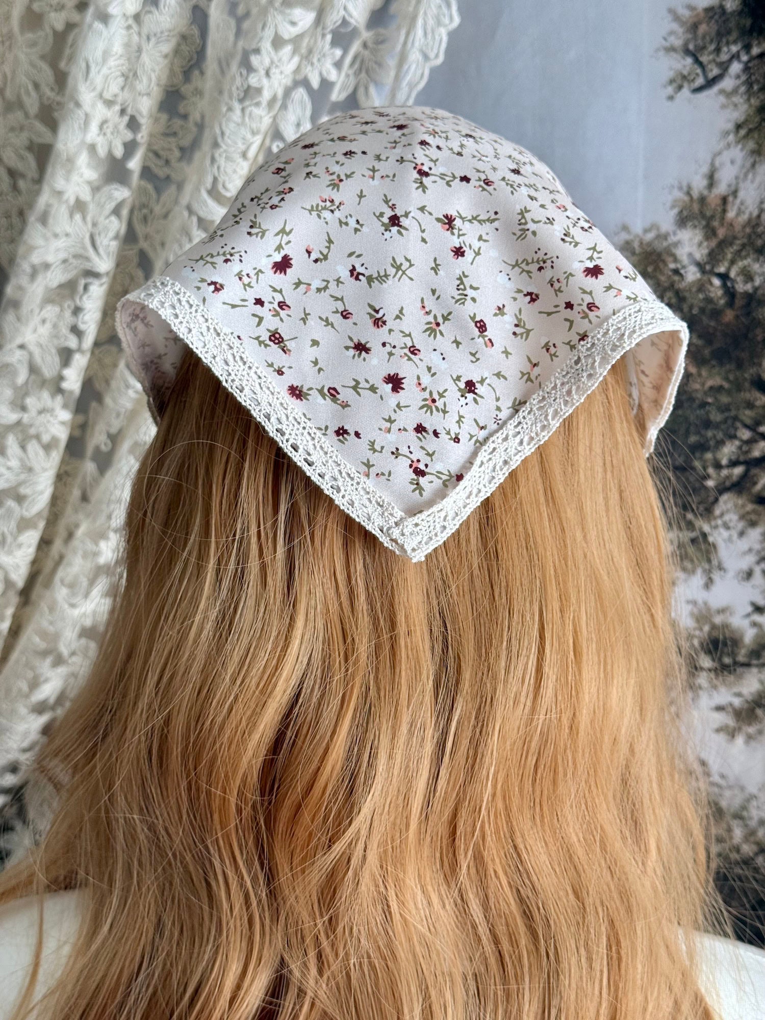 A Vintage inspired Cream & Pink Floral Print Babushka Triangle Headdress with lace trim on a mannequin head