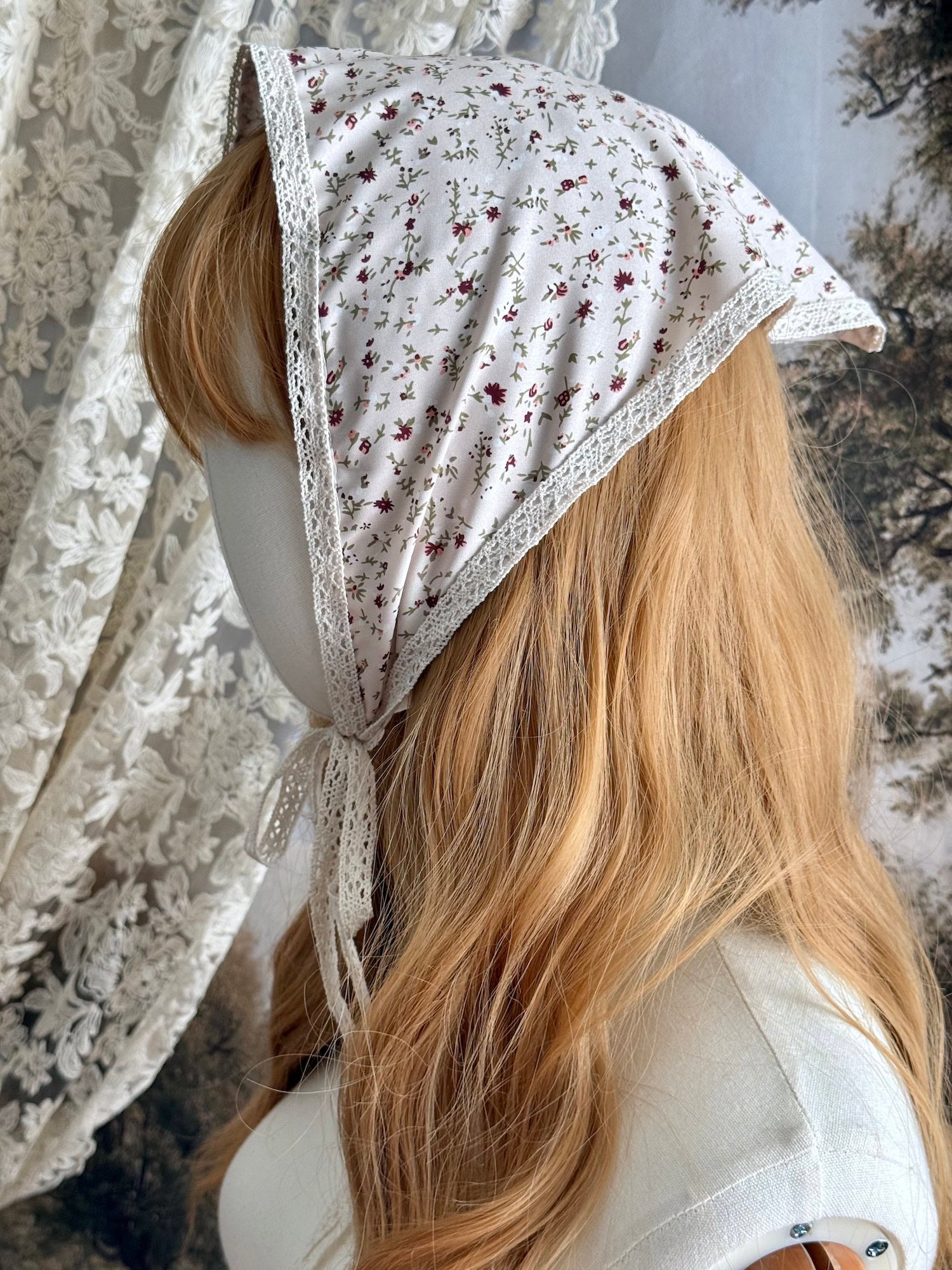 A Vintage inspired Cream & Pink Floral Print Babushka Triangle Headdress with lace trim on a mannequin head