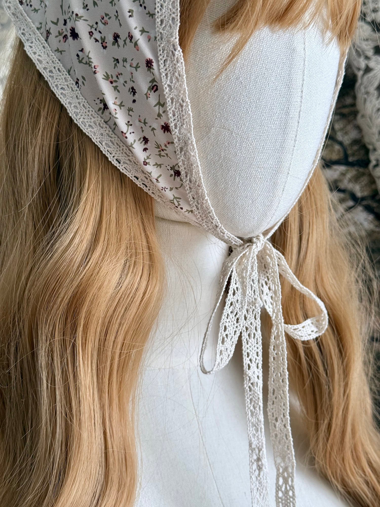 A Vintage inspired Cream & Pink Floral Print Babushka Triangle Headdress with lace trim on a mannequin head