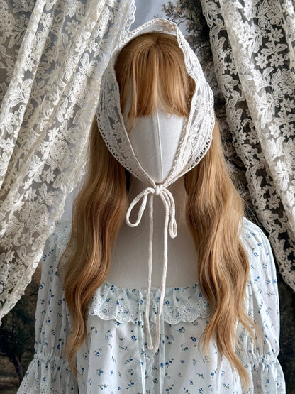 A vintage inspired ivory / cream floral embroidered lace triangle headdress babushka bonnet on a mannequin head