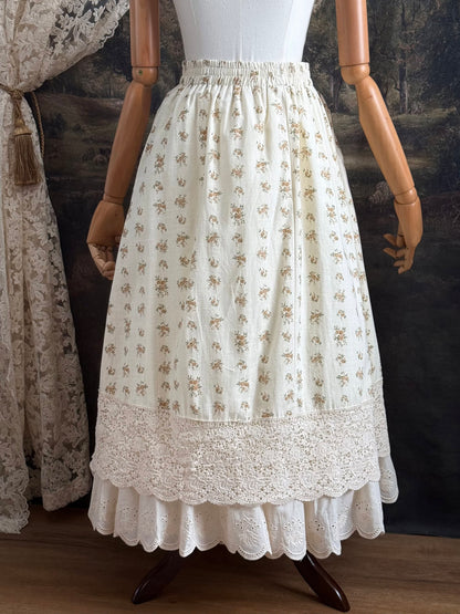 A historically inspired victorian style Ivory cotton floral printed maxi skirt with scalloped lace trim on a mannequin in front of an art history backdrop