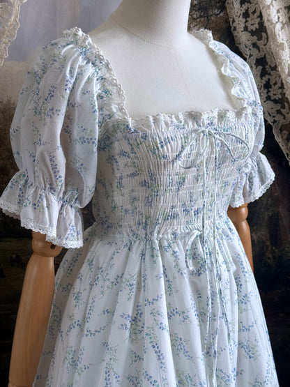 A Historically Inspired regency style puff sleeve White Floral Print Cotton Chemise maxi Dress with Shirred bodice, drawstring cinching laces, and lace trim up close.