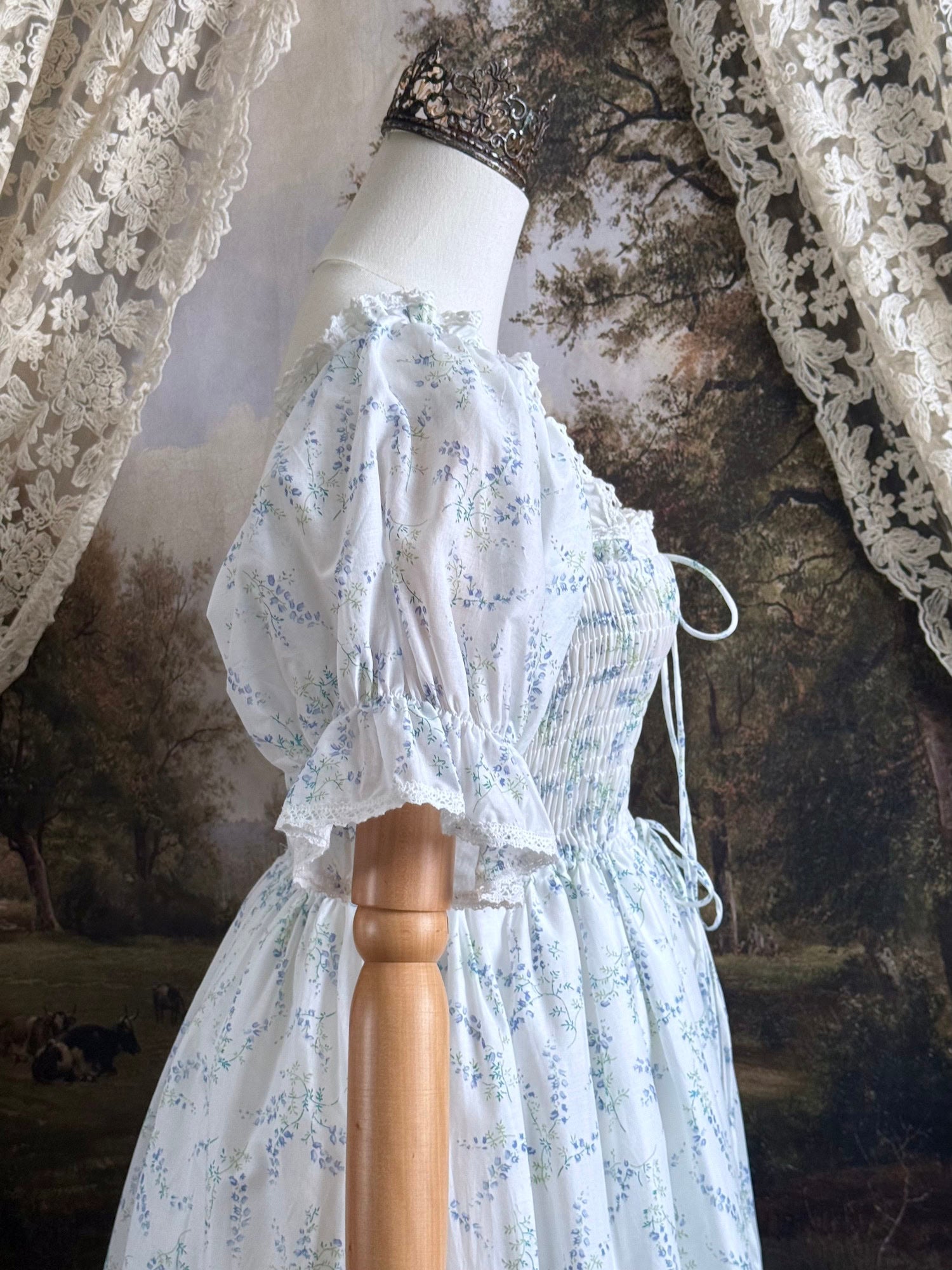 A Historically Inspired regency style puff sleeve White Floral Print Cotton Chemise maxi Dress with Shirred bodice, drawstring cinching laces, and lace trim.