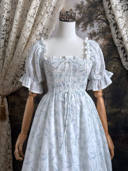 A Historically Inspired regency style puff sleeve White Floral Print Cotton Chemise maxi Dress with Shirred bodice, drawstring cinching laces, and lace trim.