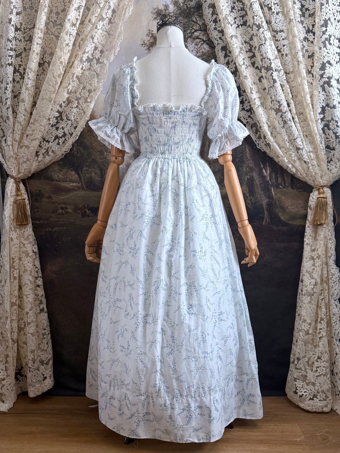 A Historically Inspired regency style puff sleeve White Floral Print Cotton Chemise maxi Dress with Shirred bodice, drawstring cinching laces, and lace trim.