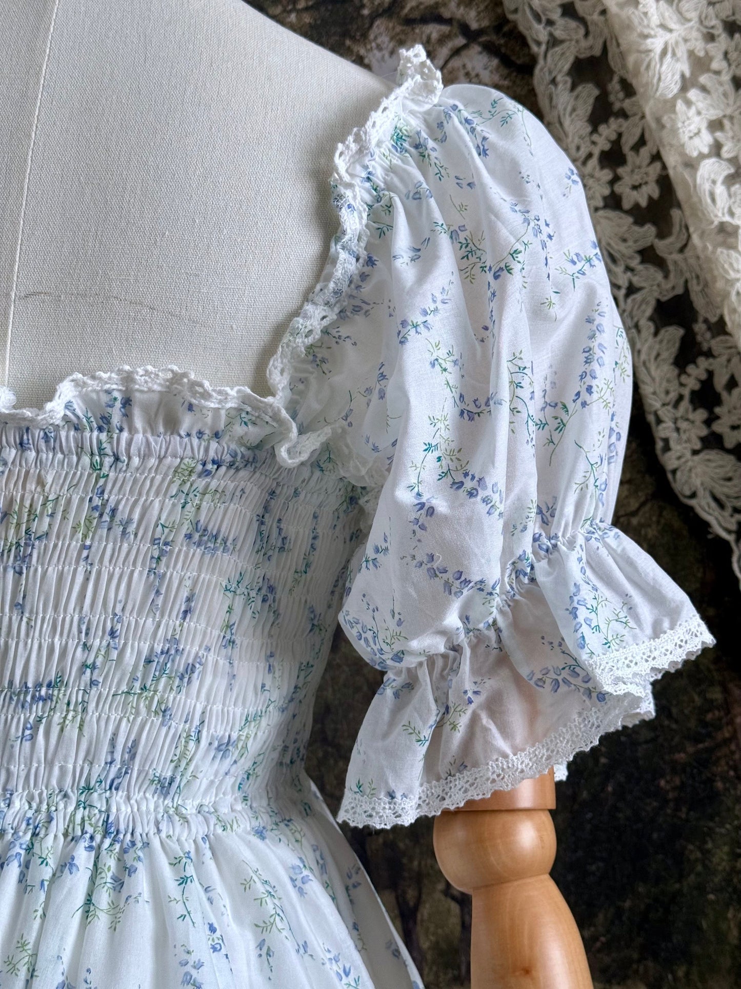 A Historically Inspired regency style puff sleeve White Floral Print Cotton Chemise maxi Dress with Shirred bodice, drawstring cinching laces, and lace trim.