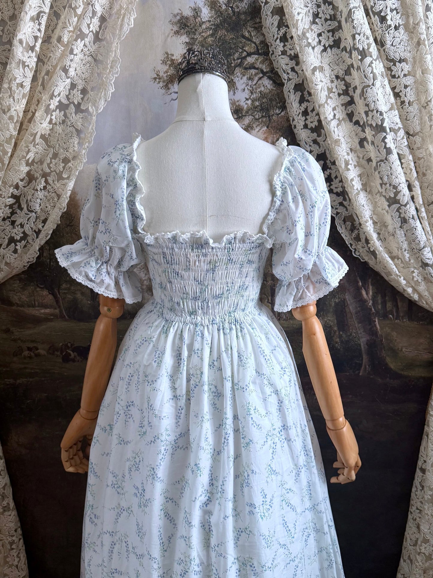 A Historically Inspired regency style puff sleeve White Floral Print Cotton Chemise maxi Dress with Shirred bodice, drawstring cinching laces, and lace trim.