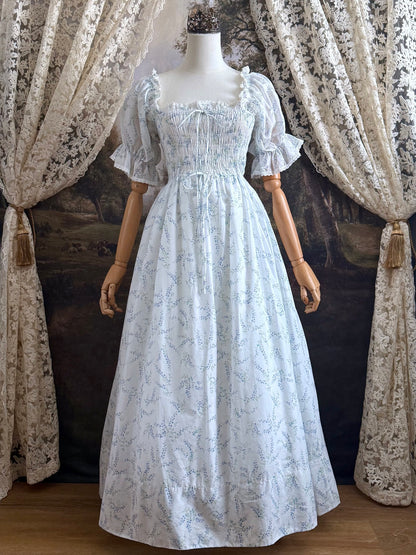 A Historically Inspired regency style puff sleeve White Floral Print Cotton Chemise maxi Dress with Shirred bodice, drawstring cinching laces, and lace trim.