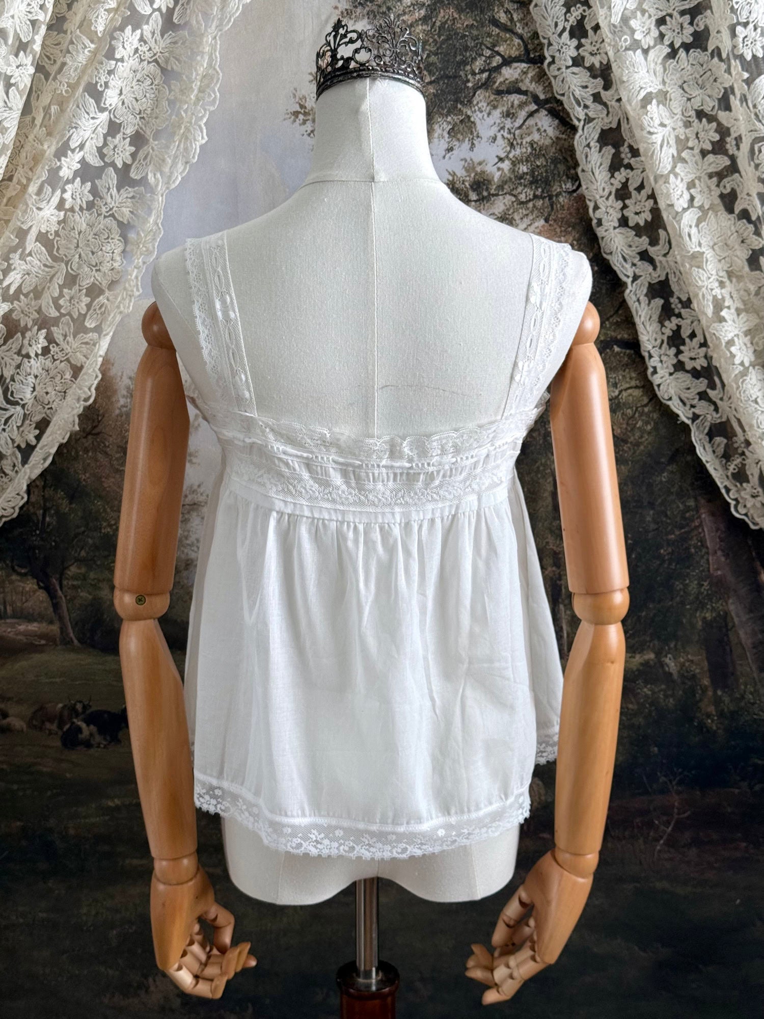 A victorian / edwardian inspired antique corset cover style tank top blouse made from white cotton and vintage design lace, pictured on a mannequin.