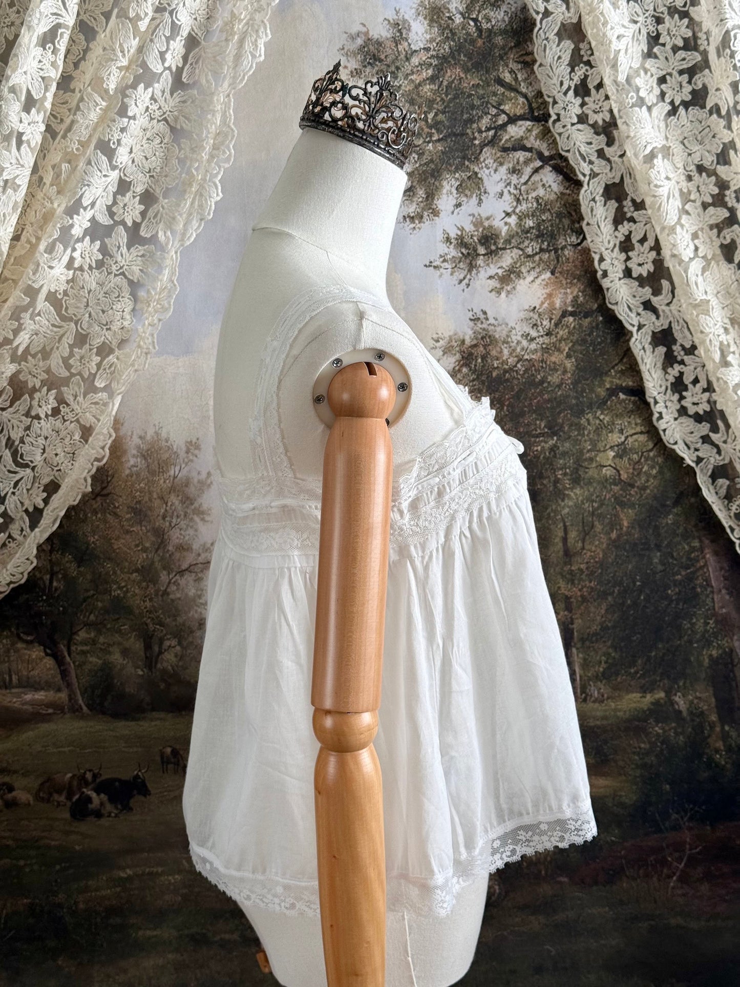 A victorian / edwardian inspired antique corset cover style tank top blouse made from white cotton and vintage design lace, pictured on a mannequin.