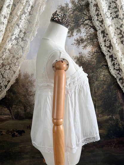 A victorian / edwardian inspired antique corset cover style tank top blouse made from white cotton and vintage design lace, pictured on a mannequin.