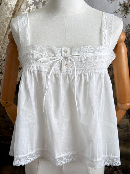 A victorian / edwardian inspired antique corset cover style tank top blouse made from white cotton and vintage design lace, pictured on a mannequin.