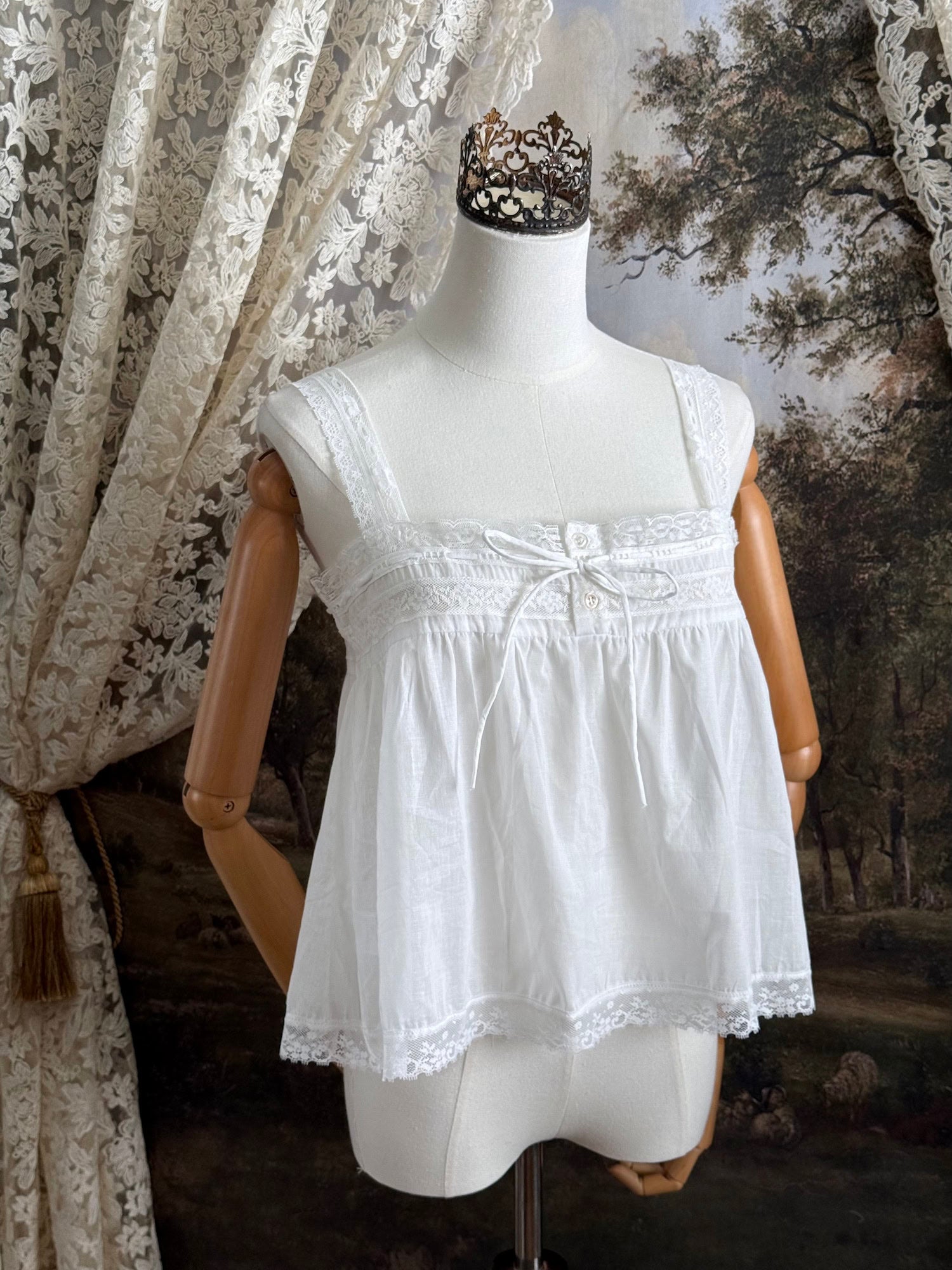 A victorian / edwardian inspired antique corset cover style tank top blouse made from white cotton and vintage design lace, pictured on a mannequin.