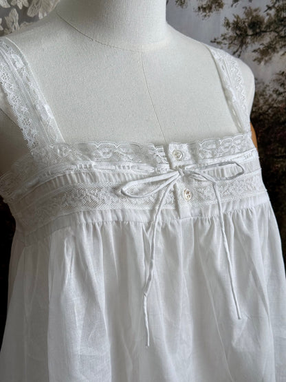 Close up of A victorian / edwardian inspired antique corset cover style tank top blouse made from white cotton and vintage design lace, pictured on a mannequin.