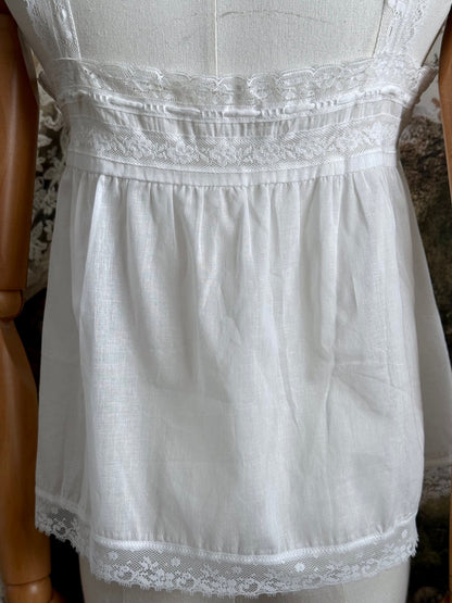 A victorian / edwardian inspired antique corset cover style tank top blouse made from white cotton and vintage design lace, pictured on a mannequin.