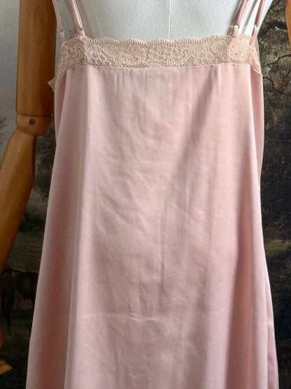 A historically inspired vintage style peachy pink satin overdress with covered buttons and lace trim on a mannequin