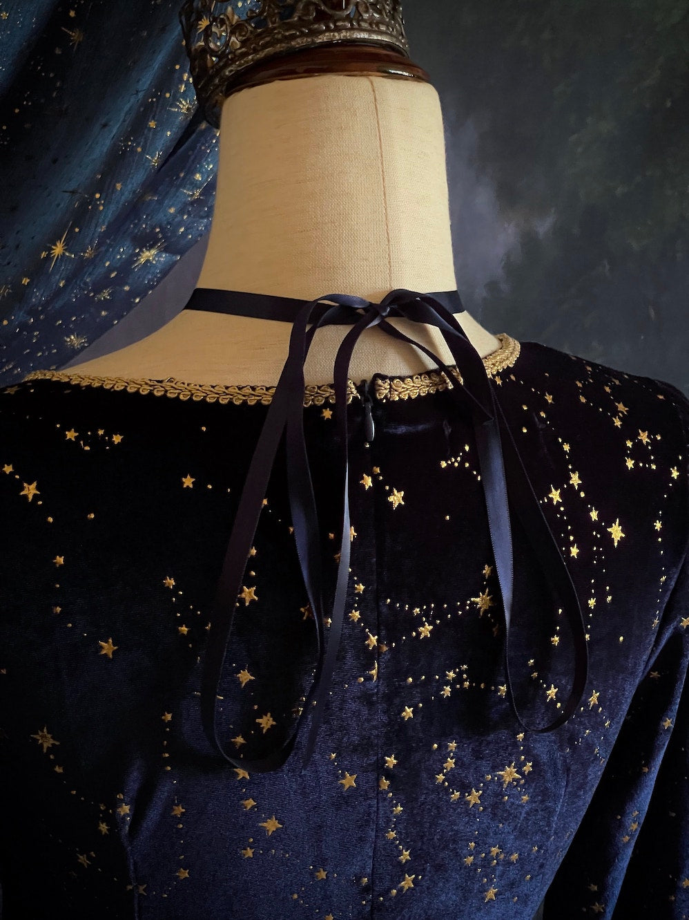 A Renaissance and Medieval Fantasy Inspired Celestial Star Velvet Bishop Sleeve Midi Dress with Satin Ribbon Neck Ties and a structured witchy whimsigoth silhouette.