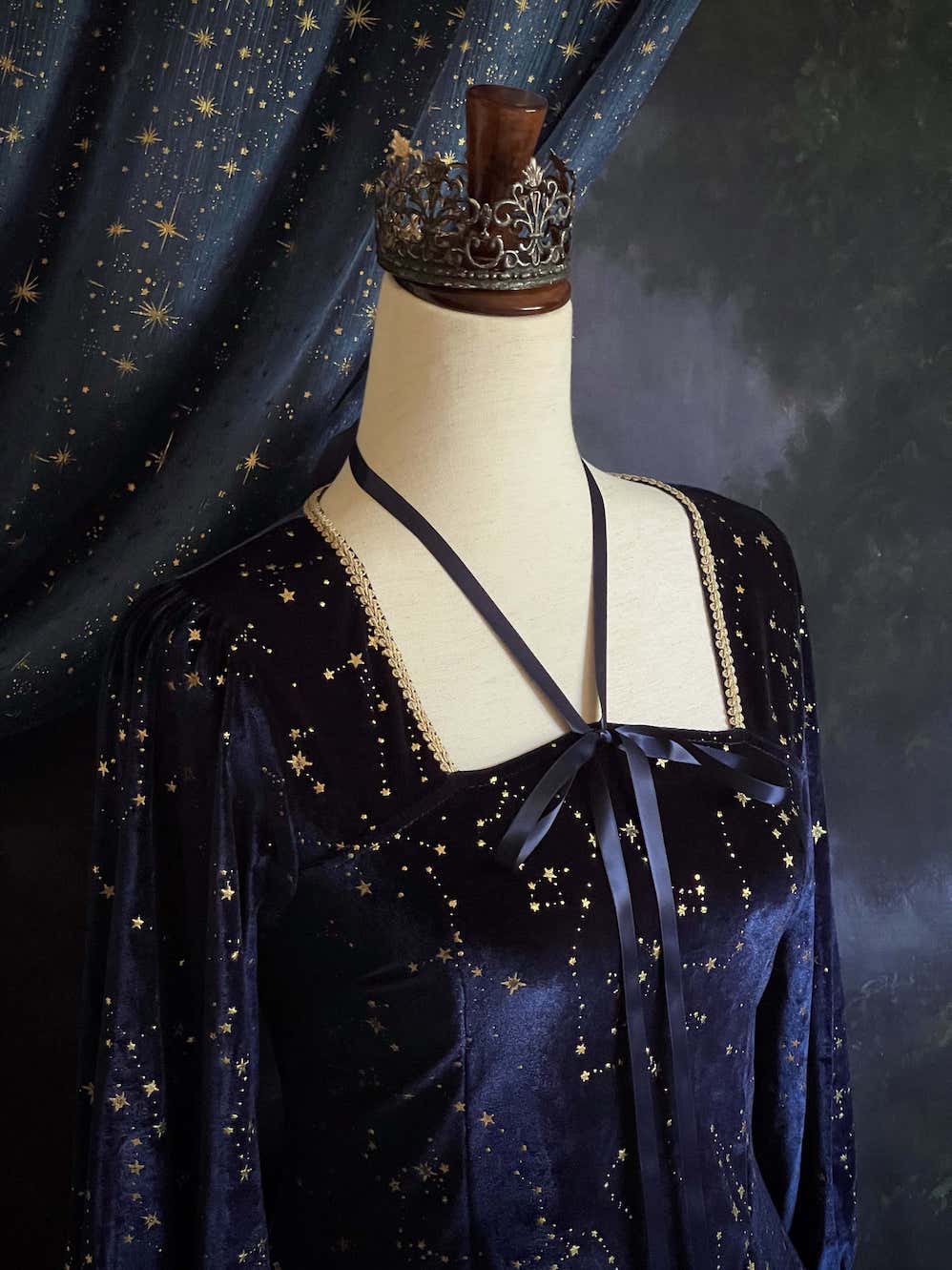 A Renaissance and Medieval Fantasy Inspired Celestial Star Velvet Bishop Sleeve Midi Dress with Satin Ribbon Neck Ties and a structured witchy whimsigoth silhouette.