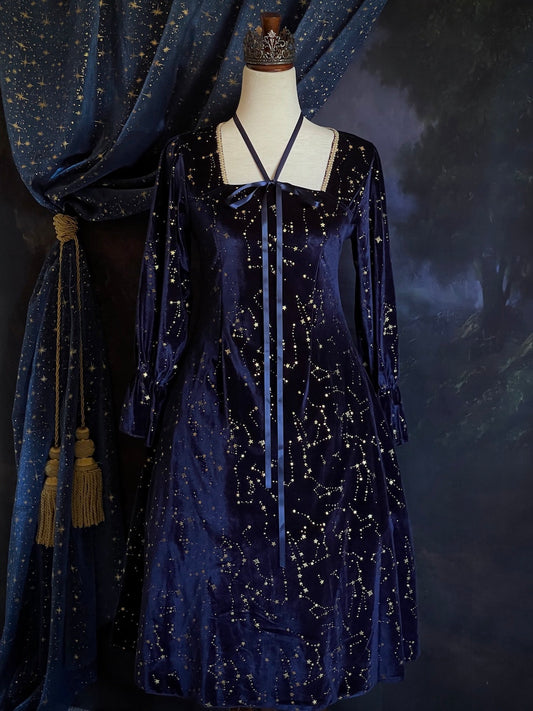 A Renaissance and Medieval Fantasy Inspired Celestial Star Velvet Bishop Sleeve Midi Dress with Satin Ribbon Neck Ties and a structured witchy whimsigoth silhouette.